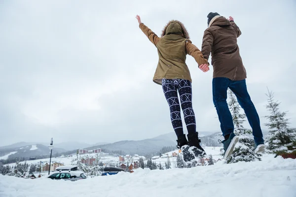 Пара стрибає і розважається разом взимку — стокове фото