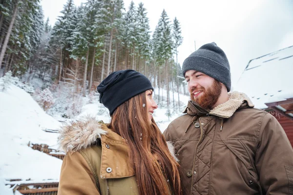Красивая улыбающаяся молодая пара в горах зимой — стоковое фото
