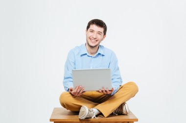 Dizüstü bilgisayar ile masada oturan casual adam