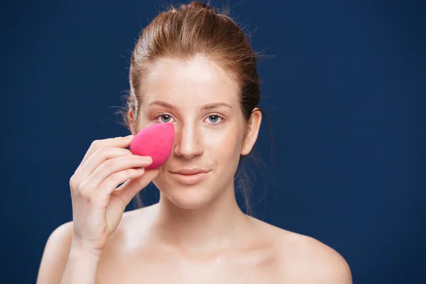 Mulher aplicando maquiagem com esponja — Fotografia de Stock