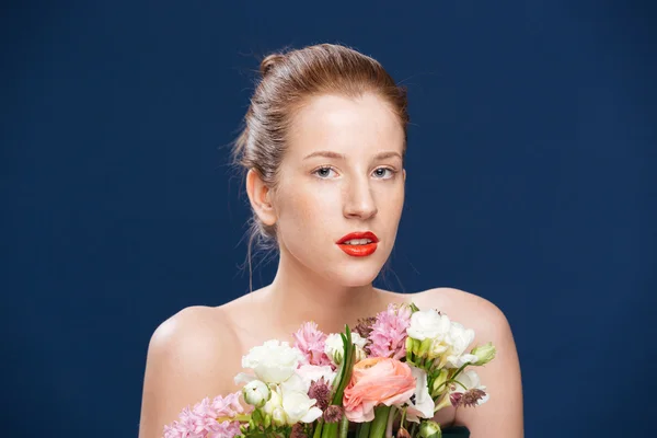 Aantrekkelijke vrouw bedrijf bloemen — Stockfoto