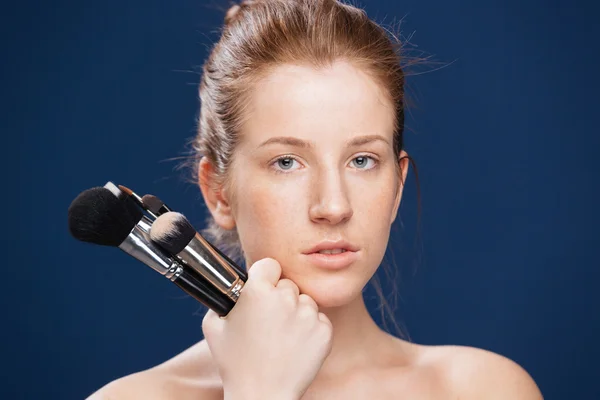 Young woman holding makeup brushes — Stock Photo, Image