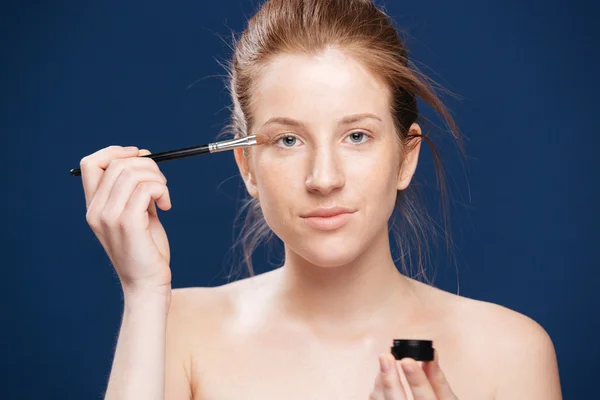 Woman applying cream on her face — Stock Photo, Image