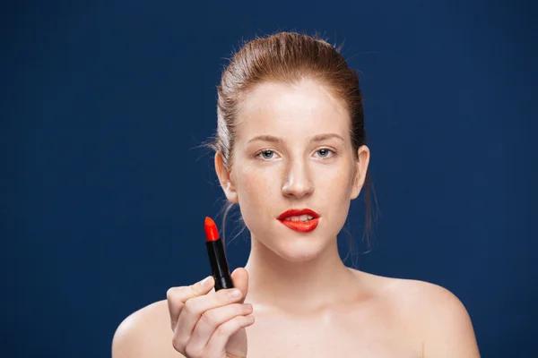 Mujer atractiva sosteniendo lápiz labial — Foto de Stock