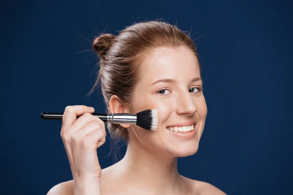 Lachende vrouw met cosmetische penseel — Stockfoto