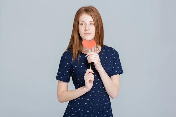 Nadenkend vrouw bedrijf rood hart — Stockfoto