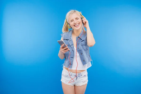 Gladlynt kvinna lyssnar musik i headsetet — Stockfoto