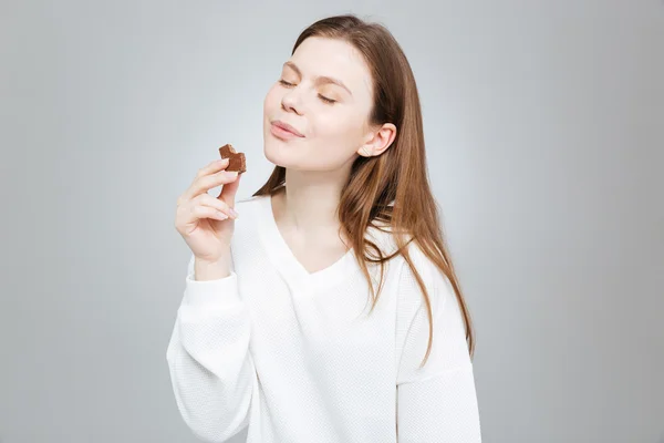 Linda menina adolescente sorridente com os olhos fechados comer chocolate — Fotografia de Stock