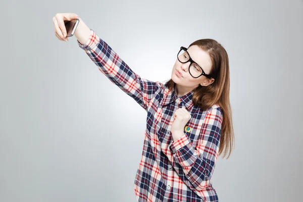 Привлекательная девушка-подросток в очках с помощью смартфона и селфи — стоковое фото