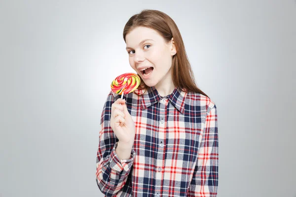 Ευτυχισμένος εφηβικό κορίτσι σε καρό πουκάμισο στέκεται και τρώει γλειφιτζούρι — Φωτογραφία Αρχείου
