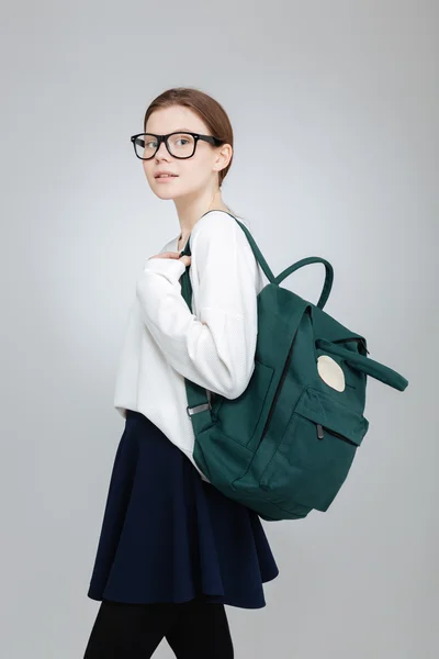 Vacker tonårsflicka i glas med grön ryggsäck — Stockfoto
