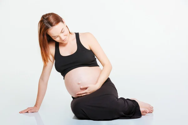 Mujer embarazada sentada en el suelo — Foto de Stock