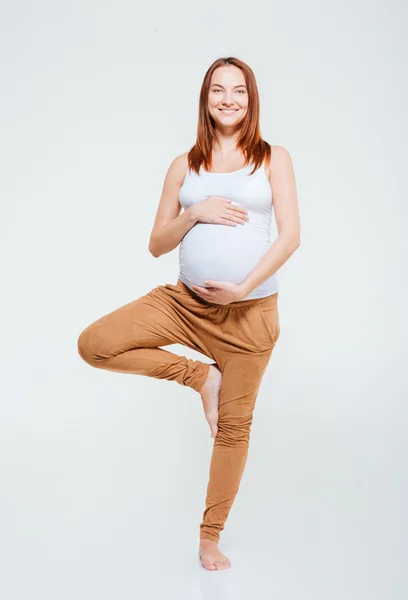 Yoga egzersiz yaparak gülümseyen hamile kadın — Stok fotoğraf