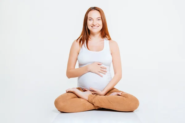 Mujer embarazada feliz sentada en el suelo — Foto de Stock