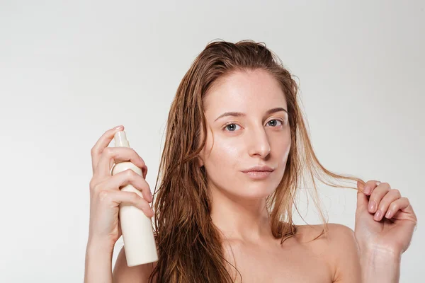 Красивая женщина распыляет лак для волос — стоковое фото