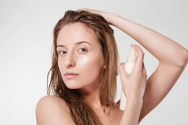 Привлекательная женщина распыляет лак для волос — стоковое фото