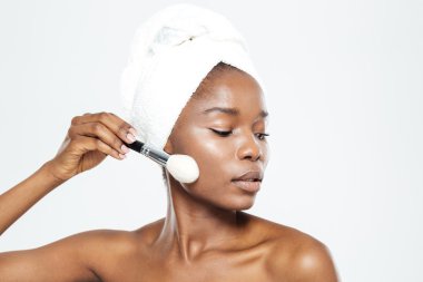 Afro Amerikalı kadın makyaj fırça ile uygulama