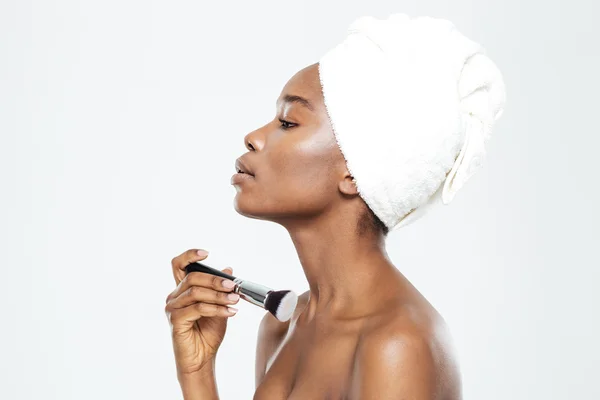 Afro americký žena použití make-up štětcem — Stock fotografie