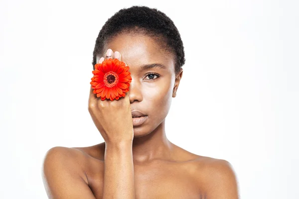 Afro amerikansk kvinna som täcker ögat med blomma — Stockfoto