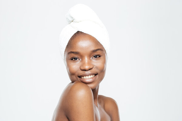 Happy afro american woman with towel on head looking at camera isolated on a white background