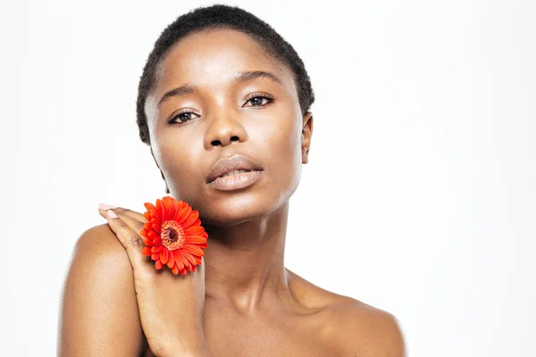 Afro amerikansk kvinna med blomma tittar på kameran — Stockfoto