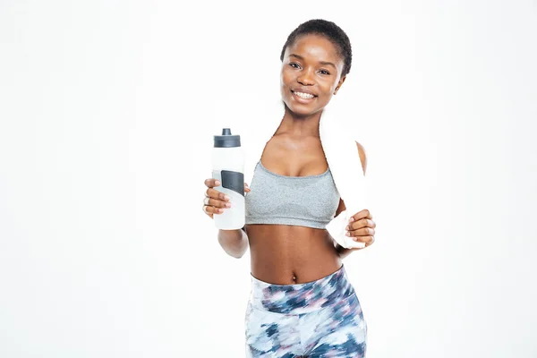 Alegre deportista afroamericana con toalla sosteniendo botella de agua — Foto de Stock