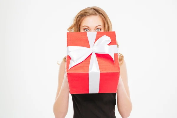 Cute lovely young woman hiding her face behing present box — Stock Photo, Image