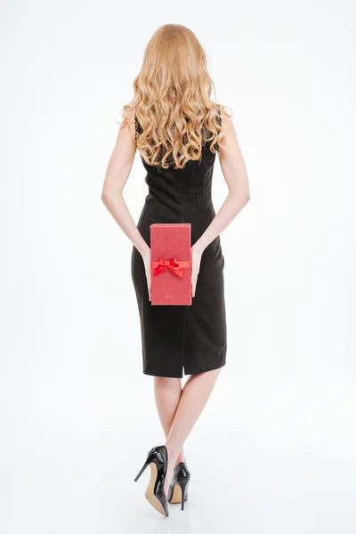 Back view of woman with long curly hair holding present — Stockfoto