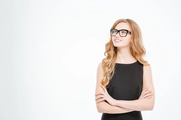 Sonriendo linda joven mujer de negocios en gafas de pie y pensando — Foto de Stock