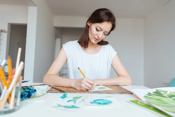 Koncentrerad kvinna målare att göra skisser med penna i art studio — Stockfoto
