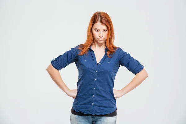 Angry irritated redhead young woman standing with hands on waist — Stock fotografie