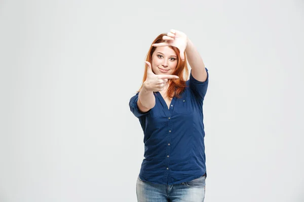 快乐有吸引力的红发年轻女子站立，使手框架 — 图库照片