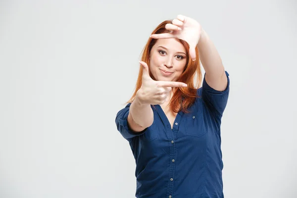 Sorridente bella rossa giovane donna che fa telaio con le mani — Foto Stock