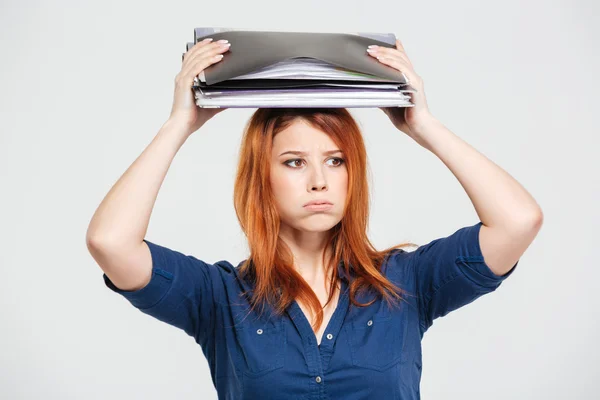 Tired sad young woman standing with folders on her head — Stock Photo, Image