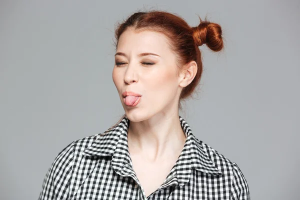 Rolig söt ung kvinna med slutna ögon visar tungan — Stockfoto