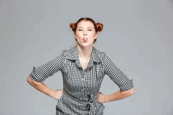 Divertido lindo joven mujer mostrando lengua y haciendo divertido cara —  Fotos de Stock