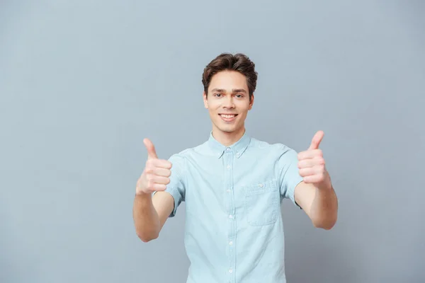 Sonriente hombre mostrando pulgares hacia arriba — Foto de Stock