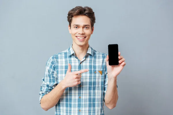 Homem sorridente mostrando tela de smartphone em branco — Fotografia de Stock