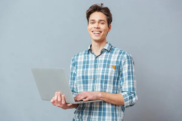 Dizüstü bilgisayar ile ayakta adam gülüyor — Stok fotoğraf