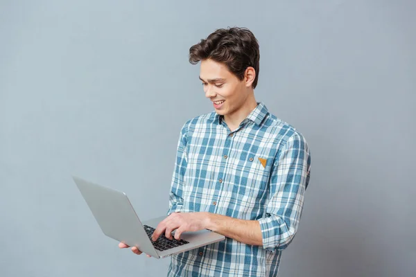 Hombre sonriente usando computadora portátil — Foto de Stock