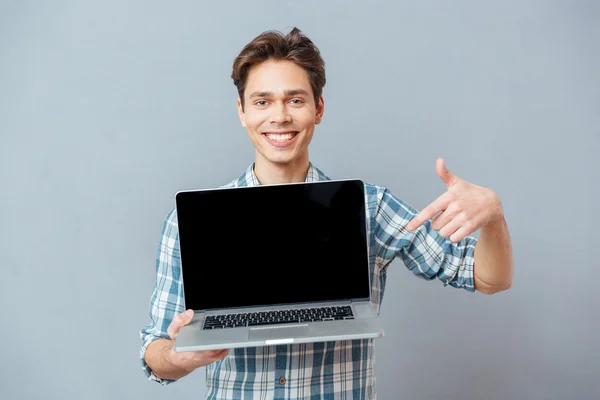 Homem feliz apontando dedo na tela do laptop em branco — Fotografia de Stock