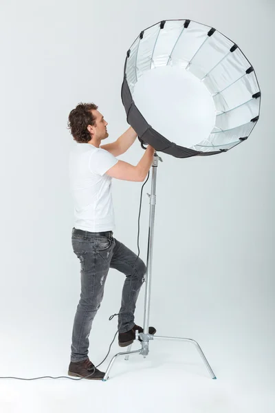 Hombre preparando equipo de iluminación —  Fotos de Stock