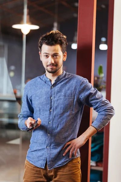 Man holding smartphone in office — Stock Photo, Image