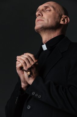 Gözleri kapalı ve dua ile ayakta rahip 