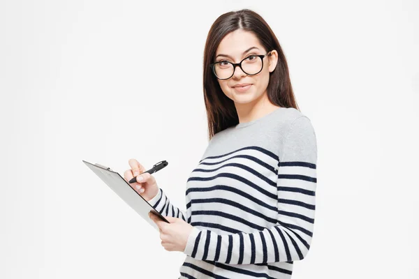 Happy woman writing notes in clipboard — Stock Photo, Image