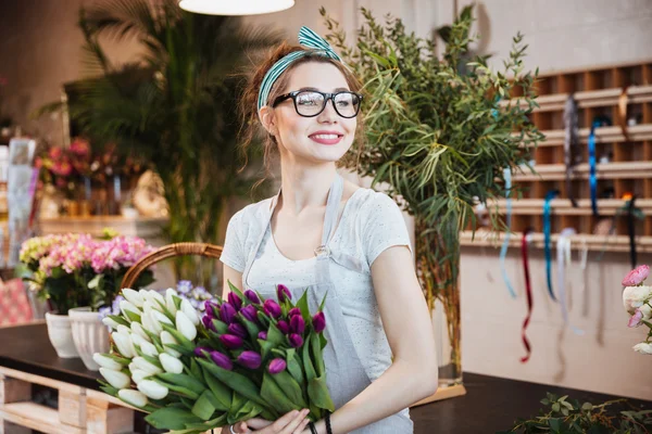 Vrouw bloemist met wit en paars tulpen in bloemenwinkel — Stockfoto