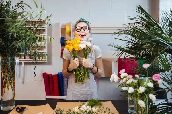 Mujer feliz florista con ramo de flores de pie y riendo —  Fotos de Stock