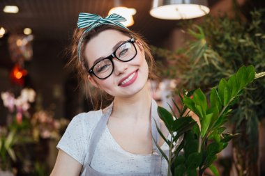 Neşeli genç ve güzel kadın Çiçekçi Çiçek dükkanında bardaklarda
