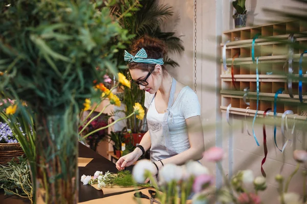 Floristin stellt Blumenstrauß her und arbeitet im Blumenladen — Stockfoto