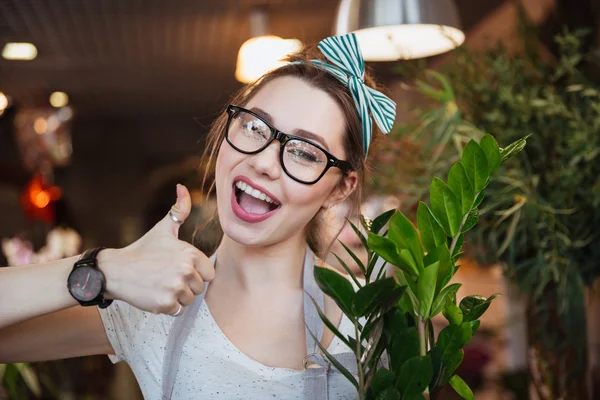 Joyeux fleuriste femme montrant pouces dans la boutique de fleurs — Photo